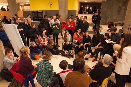 People sitting in a circle listening to a presenter