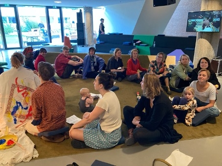 People sitting in a circle looking at each other's back